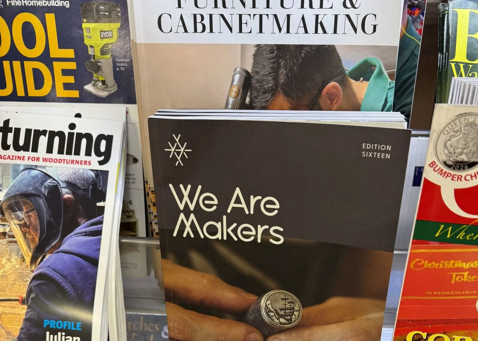 A newsstand rack of specialist magazines — woodturning, furniture and cabinetmaking, homebuilding, birdwatching — with the sixteenth edition of an independent magazine for makers at the front.